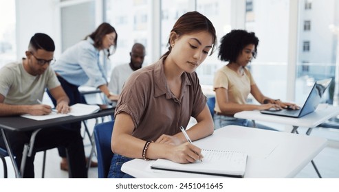 Woman, students and writing with test in classroom for exam, study or assignment at university. Female person or group busy on project or essay with notebook for higher education, lesson or learning - Powered by Shutterstock