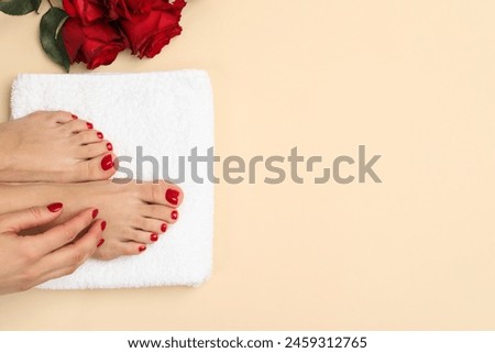 Woman with stylish red toenails after pedicure procedure and rose flowers on beige background, top view. Space for text