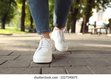 Woman in stylish sneakers walking on city street, closeup - Powered by Shutterstock