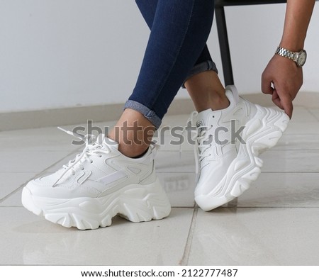 Woman in stylish sport shoes or 
Chunky Shoes on Foot