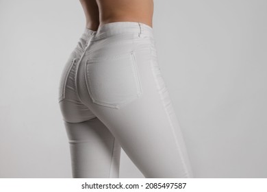 Woman In Stylish White Jeans On Light Background, Closeup