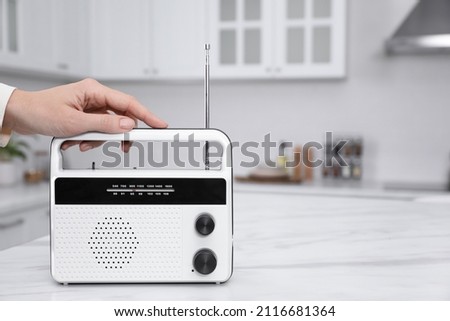 Woman with stylish white radio in kitchen, closeup. Space for text