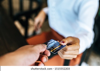 Woman submitting credit card to pay for goods