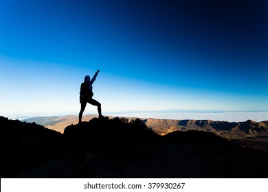 Woman successful hiking climbing silhouette in mountains, motivation and inspiration landscape on island and ocean. Hiker with arms up outstretched on mountain top looking at beautiful view.