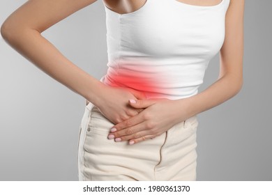 Woman suffering from appendicitis inflammation on grey background, closeup - Shutterstock ID 1980361370