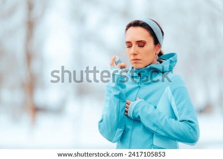 
Woman Suffering an Asthma Attack After Running in the Cold. Asthmatic person managing condition with medication in cold season 
