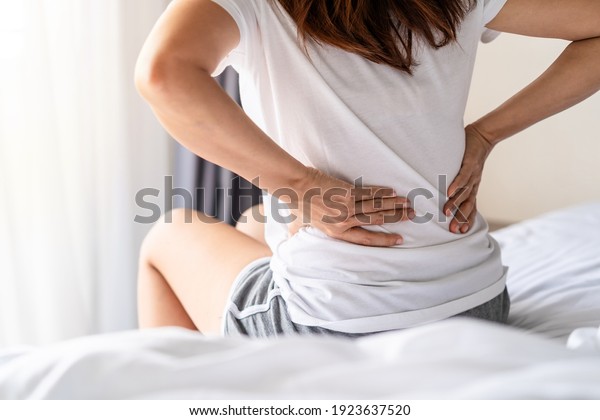 Woman suffering from back ache on the bed,\
healthcare and problem\
concept