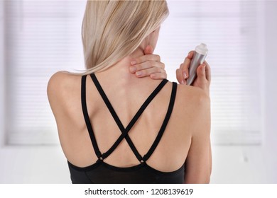 Woman Suffering From Back Pain Applying Pain Relief Cream . Sports Exercising Injury.