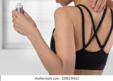 Woman Suffering From Back Pain Applying Pain Relief Cream . Sports Exercising Injury.