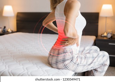 Woman suffering from back pain because of uncomfortable mattress