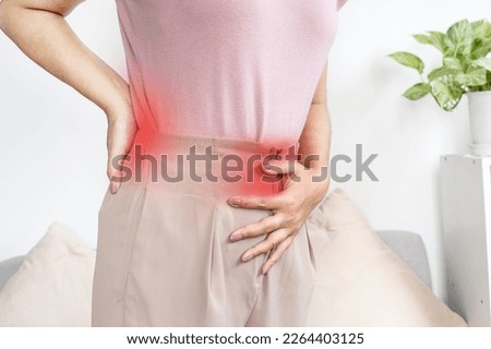 woman suffering from back pain and stomach pain during menstrual period 