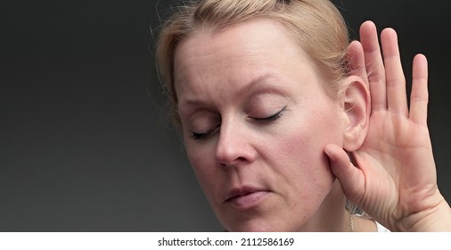 woman suffering from deafness and hearing loss on grey background sock photo