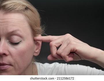woman suffering from deafness and hearing loss on grey background stock photo