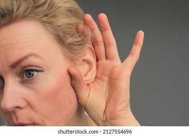 woman suffering from deafness and hearing loss on grey background stock photo