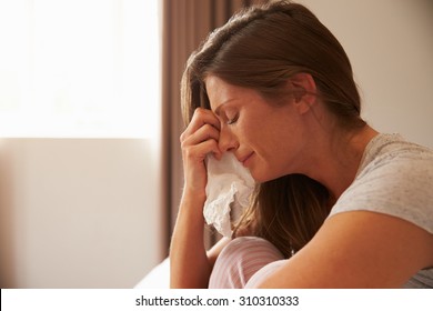 Woman Suffering From Depression Sitting On Bed And Crying - Shutterstock ID 310310333