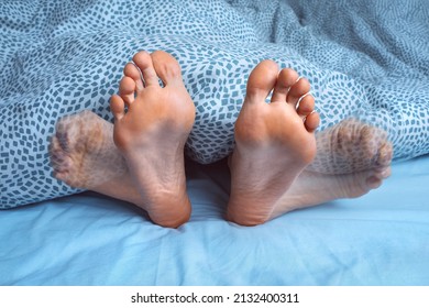 Woman suffering from foot cramps, leg cramps or muscular spasm while sleeping. Feet pain or feet ache at night. Restless legs syndrome