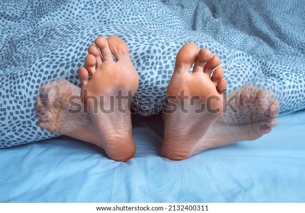 Woman suffering from foot cramps, leg cramps or\
muscular spasm while sleeping. Feet pain or feet ache at night.\
Restless legs syndrome