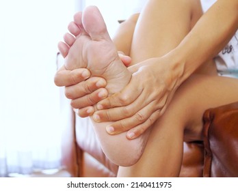 Woman Suffering From Foot Pain And Feeling Numb With Inflamed Nerves Or Degenerative Bones.