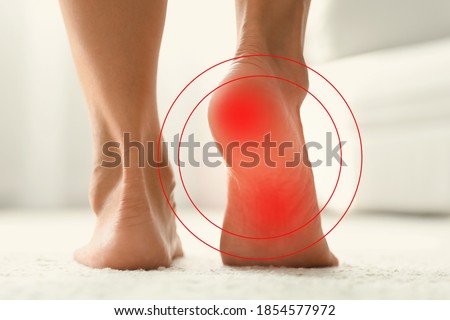 Woman suffering from foot pain at home, closeup 