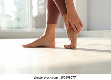 Woman suffering from foot pain indoors, closeup