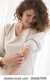 Woman Suffering From  Itching Her Arm