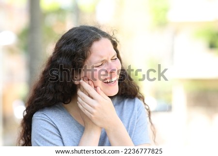 Woman suffering jaw ache in the street