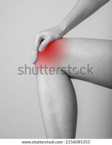 Woman suffering from knee pain. Tendonitis, sprains, strains, tears, arthritis, repeated pressure consequences. Female foot closeup. Black and white. High quality photo