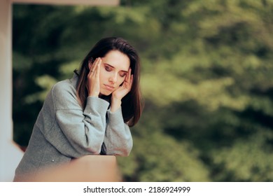 
Woman Suffering From A Migraine Standing In The Balcony. Unhappy Person Feeling Unwell Having A Headache
