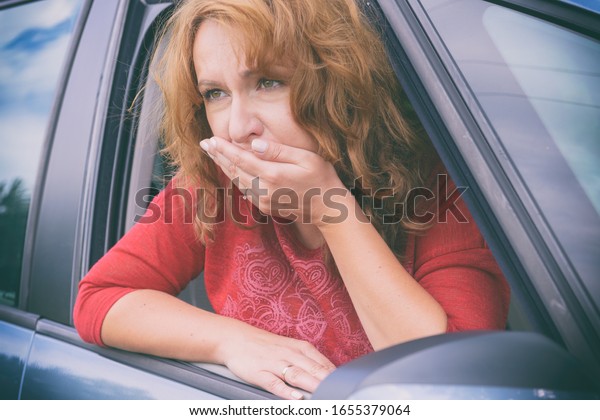 Woman suffering\
from motion sickness in a\
car