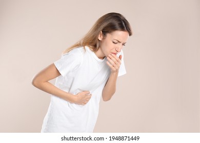 Woman Suffering From Nausea On Beige Background. Food Poisoning