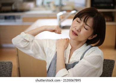 A woman suffering from stiff shoulders  - Shutterstock ID 2135067895