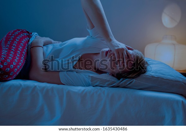 Woman\
suffering from stomachache  in bed at night at home. Woman Laying\
having stomach ache. Young woman in abdominal\
pain