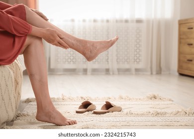 Woman suffering from varicose veins at home, closeup. Space for text