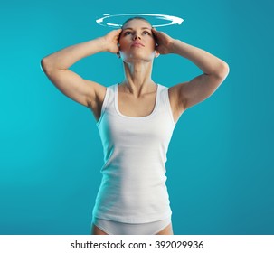 Woman Suffering From Vertigo And Dizziness Over Blue Background. Young Female Touching Her Head In Pain. Concept Of Health Diagnosis And Treatment.  