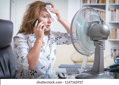 Woman Suffers From Heat While Working In The Office And Tries To Cool Off By The Fan