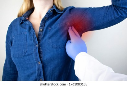 A woman suffers from pain in the armpit. Sweating, unpleasant odor, redness, tooth and inflammation in the armpit. Breast Cancer Prevention Concept