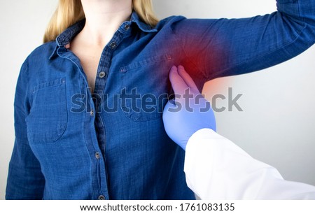 A woman suffers from pain in the armpit. Sweating, unpleasant odor, redness, tooth and inflammation in the armpit. Breast Cancer Prevention Concept