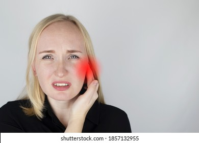 A woman suffers from pain in the ear. The auditory meatus hurts due to otitis media, cerumen plug, ear boil, or trigeminal neuralgia. On examination by a doctor.