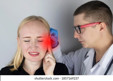 A woman suffers from pain in the ear. The auditory meatus hurts due to otitis media, cerumen plug, ear boil, or trigeminal neuralgia. On examination by a doctor.