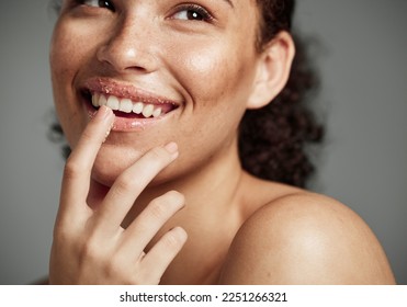 Woman, sugar scrub and lips with smile for skincare, makeup or cosmetics against a grey studio background. Happy female smiling in happiness for facial cosmetic, lip dermatology or mouth exfoliation