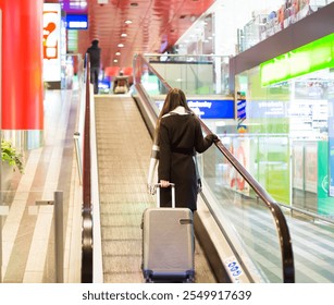 Woman with Suitcase Ascending Escalator at Train Station - Powered by Shutterstock