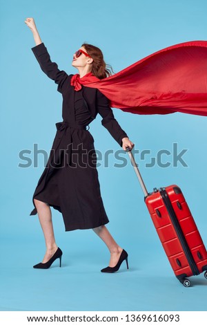 A woman with a suitcase and in a black coat heels shoes red cloak