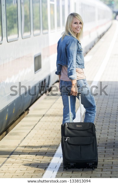 Woman with suitcase on the\
platform