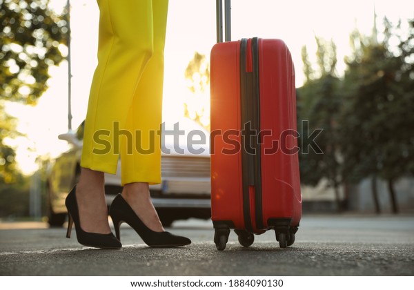 Woman with suitcase waiting for taxi on city
street, closeup