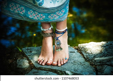 woman summer boho fashion style barefoot with jewelry anklets and rings stand on stone outdoor summer day