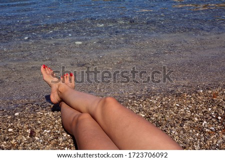 Woman sunbathing her feet on a beautiful beach