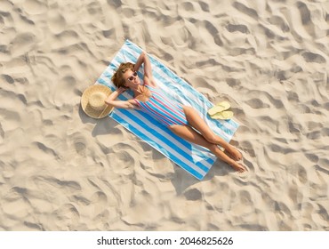 Woman Sunbathing On Beach Towel At Sandy Coast, Aerial View