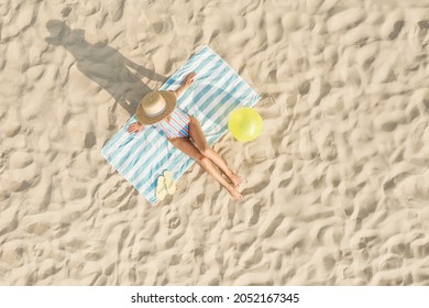 Woman Sunbathing On Beach Towel At Sandy Coast, Aerial View