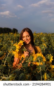 Woman With Sunflower In Her Hand On The Field. Yellow Eye Shadow And Manicure.