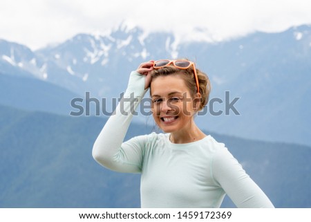 Woman with sunglasses perched on head squints and poses at Hurricane Ridge in Washington States Olympic National Park